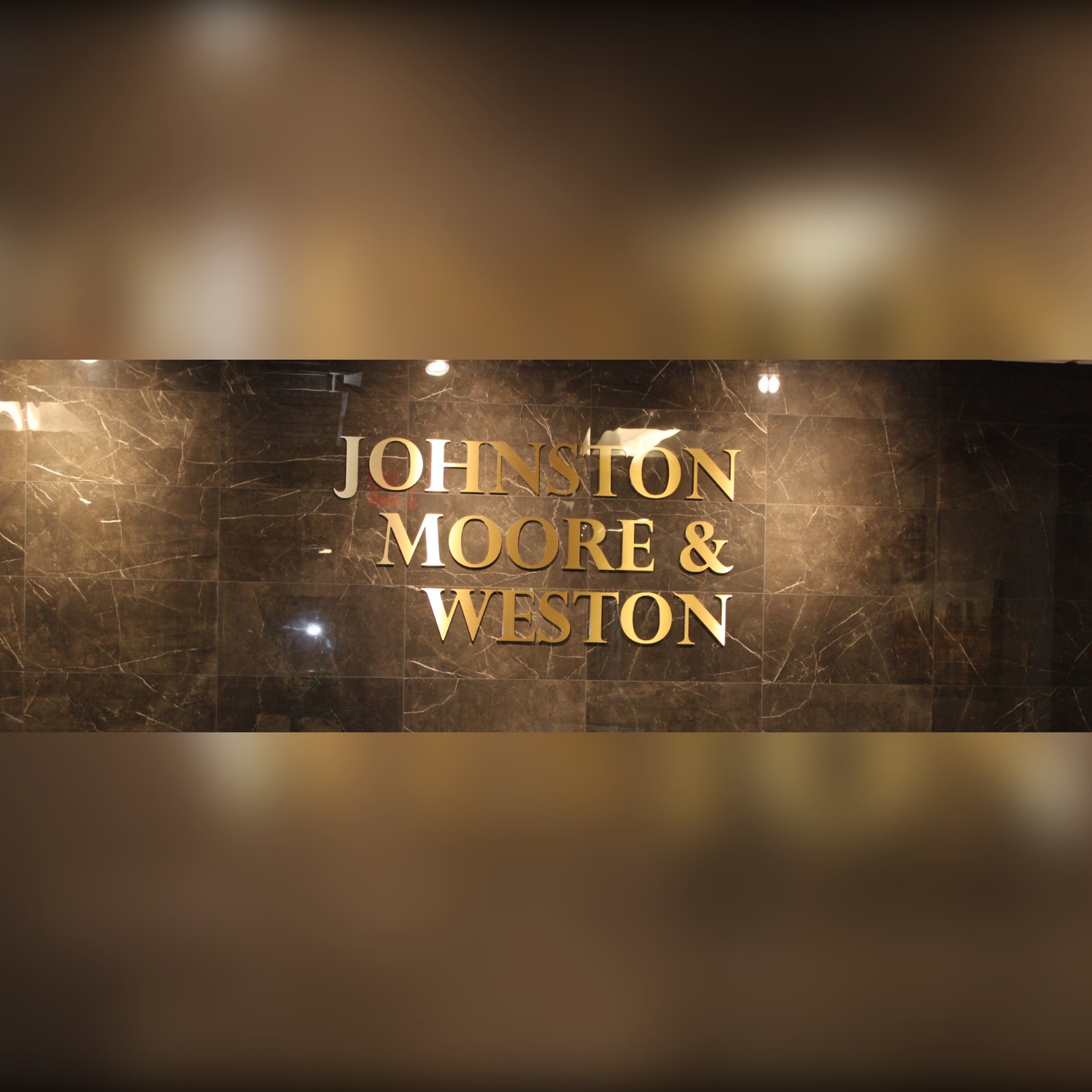 The Johnston, Moore & Weston reception — gold lettering on dark marble
